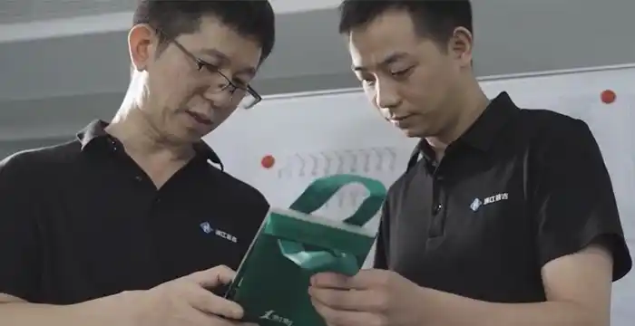 A production manager pointing at a registration error on a printed film roll